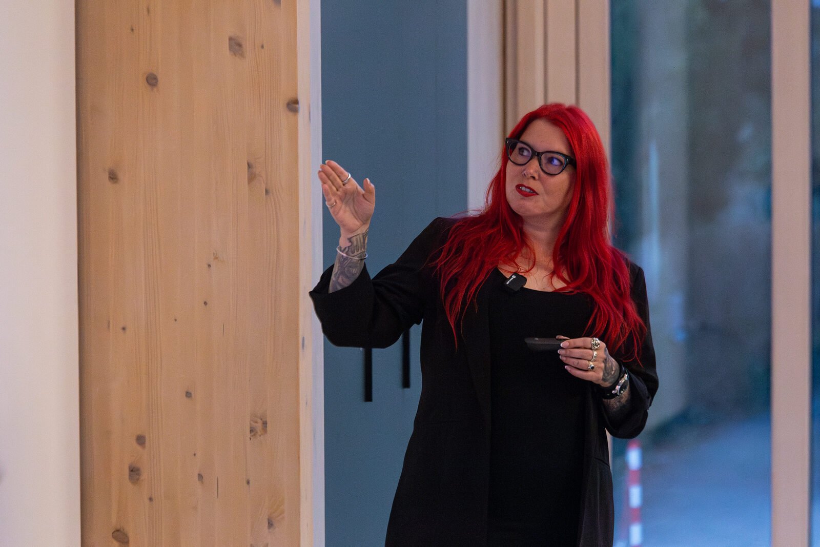 Ronia Fraser gesturing mid-explanation while speaking, wearing a lapel microphone